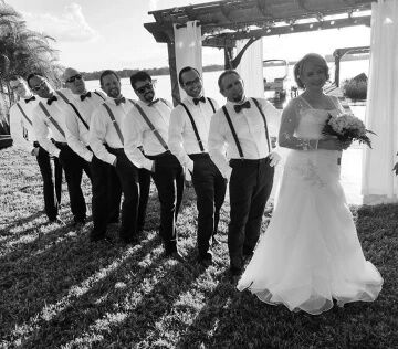 bride standing with all of the groomsmen behind her